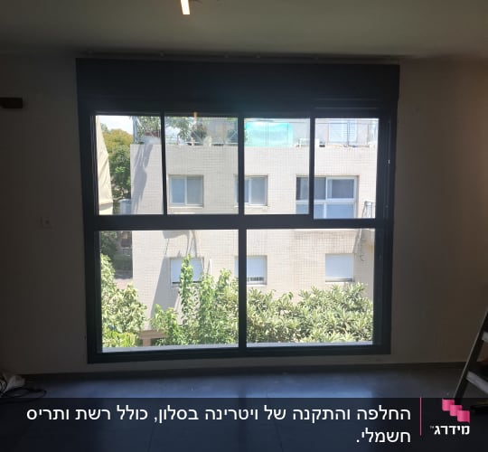 חלון אלומיניום גדול עם נוף לבניין ועצים בחוץ.